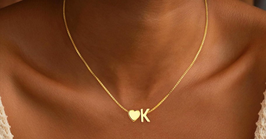 woman wearing gold necklace with heart and letter K pendants