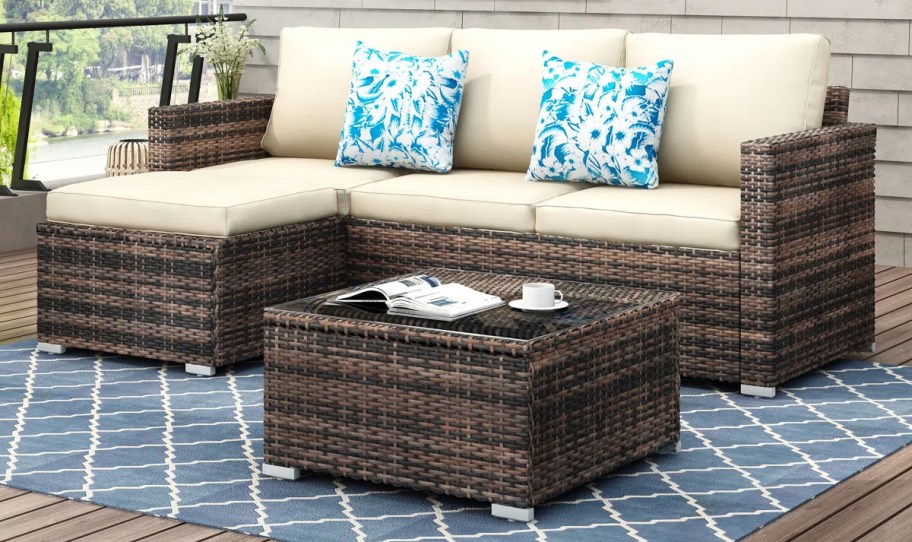 wicker sectional with white cushions and coffee table