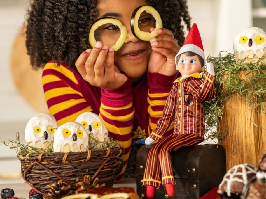 Little girl with an Elf on the Shelf wearing Hogwart's Griffindor Harry Potter Pajamas