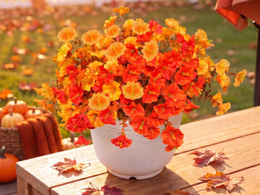 yellow and orange flowers in a white planter