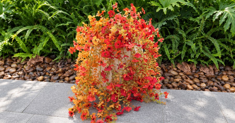 yellow and orange faux flowers draping over a pot