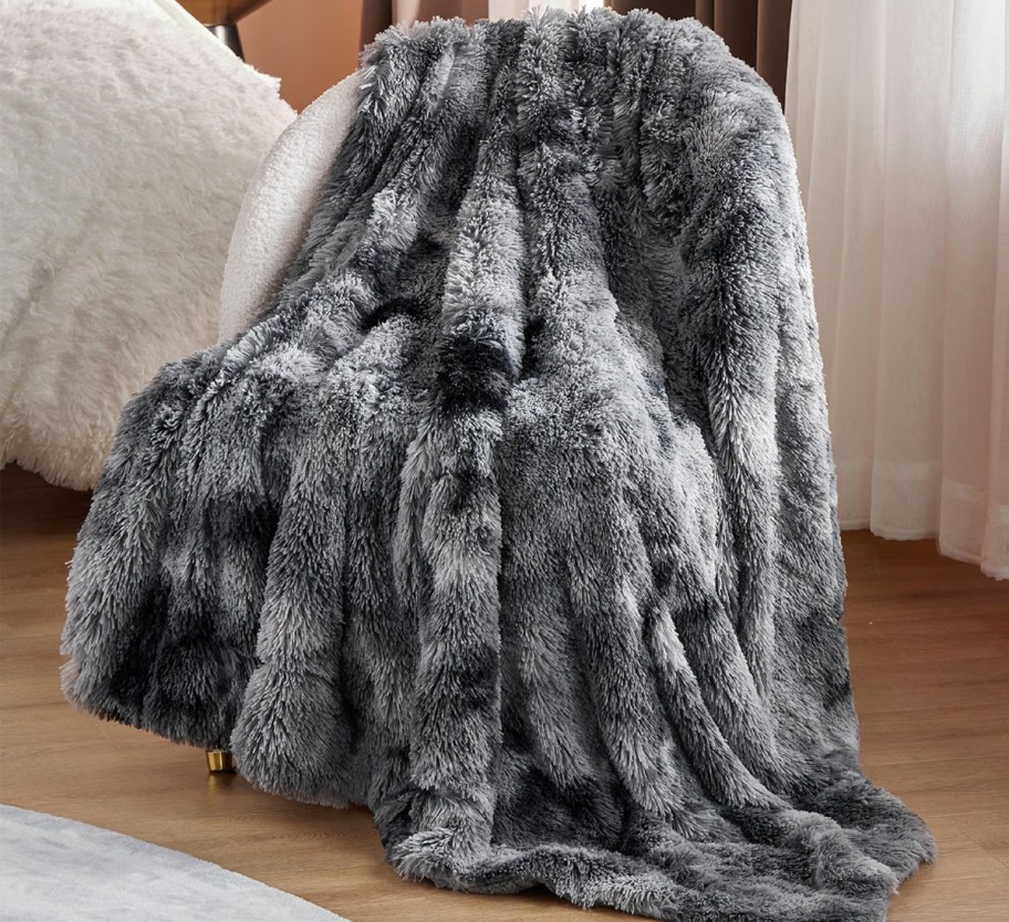 grey fluffy throw blanket draped over a chair