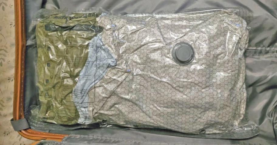 clothes inside of a vacuum seal bag in a piece of luggage