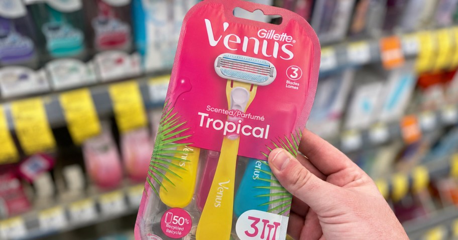 hand holding up a pack of Gillette Venus Tropical Razors in store aisle