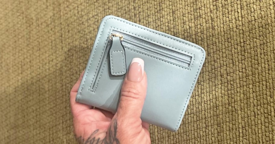 hand holding up a light blue wallet