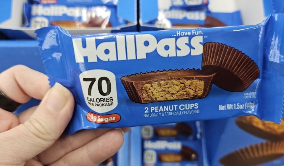 Hand holding Hall Pass candy peanut cups at the store