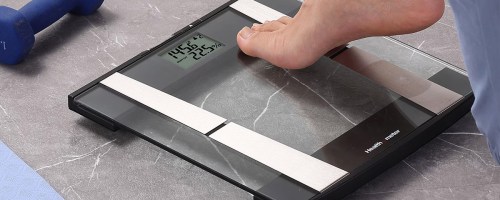 person stepping onto a glass scale
