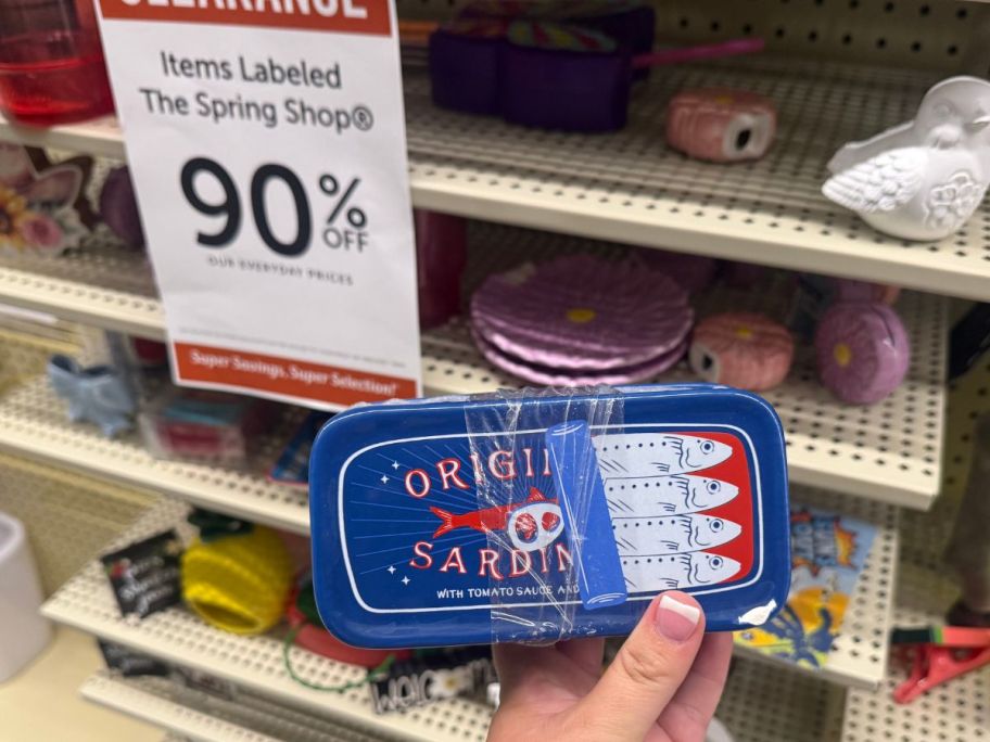 Hand holding a Sardine Butter Dish in front of a 90% off Hobby Lobby Clearance sign
