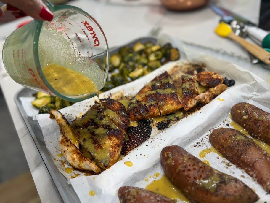pouring maple dijon sauce over chicken 