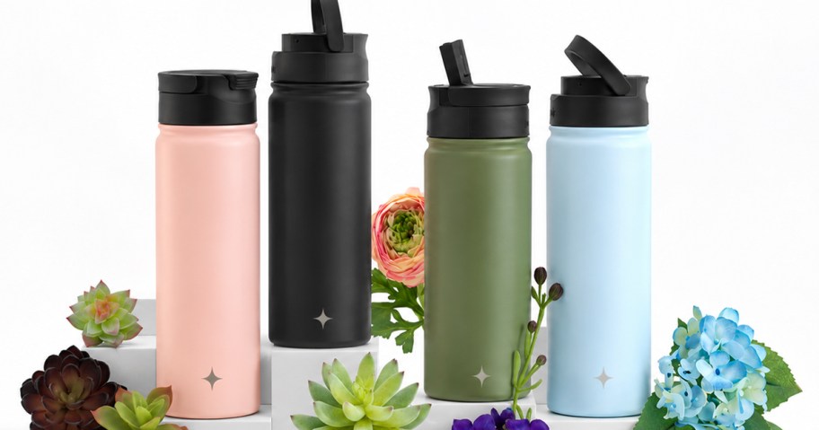 pink, black, green, and blue water bottles with flowers around them