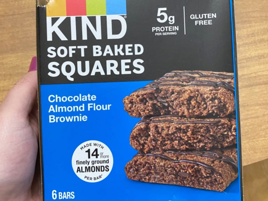 hand holding a blue box of KIND Soft Baked Squares