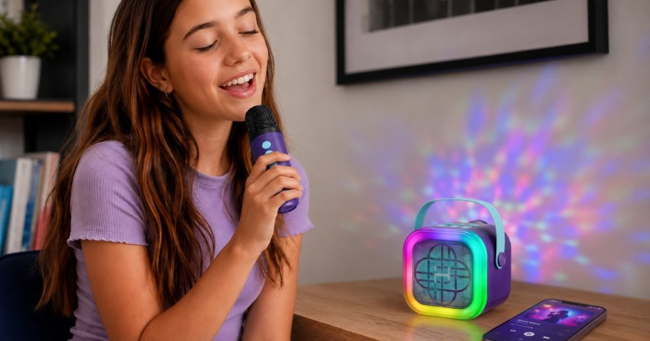 Girl singing with a purple mini karaoke machine and colorful light show