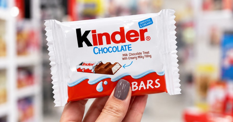 hand holding up a kinder bar in store