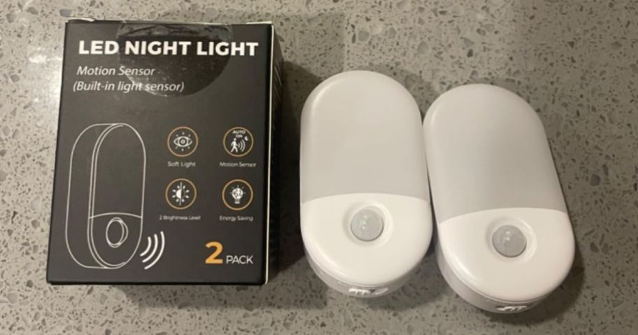 A box with two Motion Sensor LED Night Lights next to it