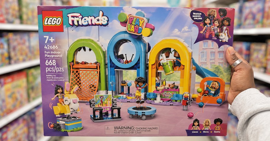hand holding up LEGO Friends Fun Indoor Playground box in store aisle