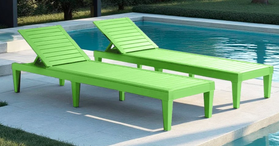 two green chaise lounge chairs near a pool