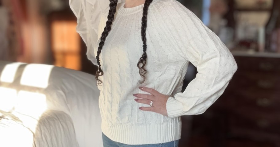 woman wearing white cable knit merokeety sweater in bedroom