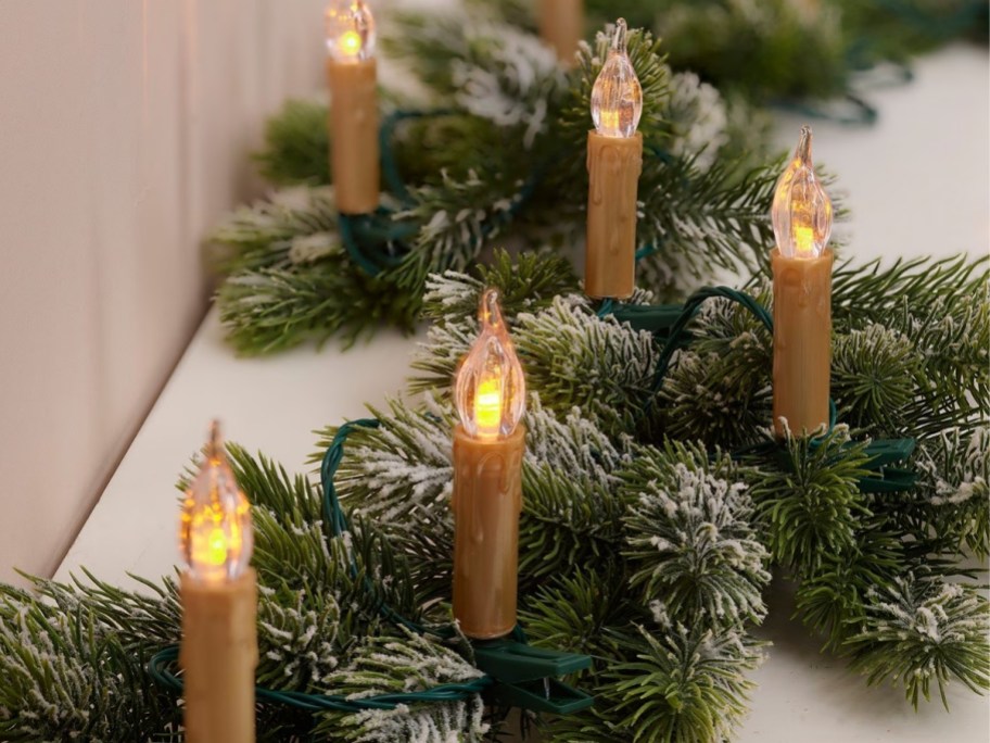 flickering candle lights on a struip of green garland
