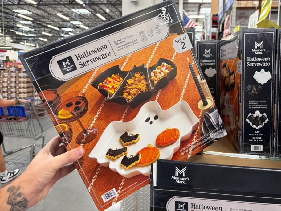 hand grabbing Member's Mark Halloween Ghost & Bat Serving Set box from store display