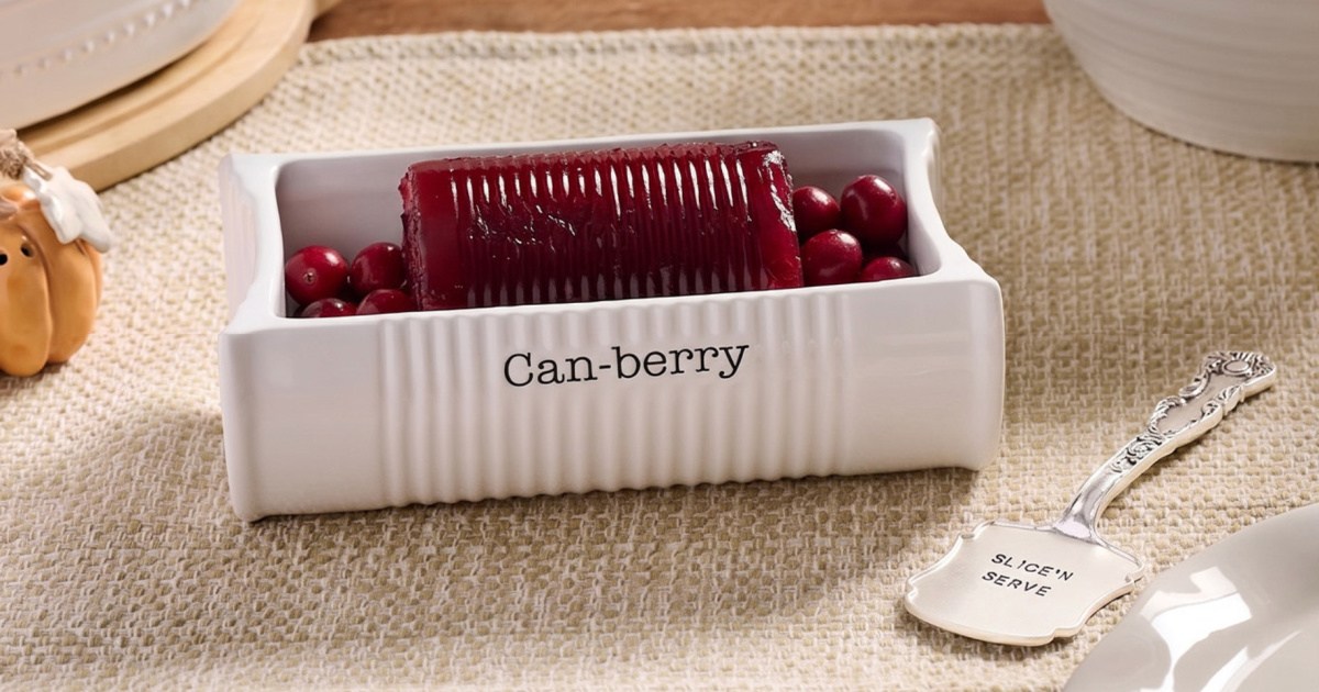 White ceramic cranberry dish next to silver serving spoon on Thanksgiving table