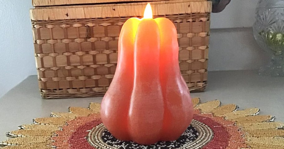 orange pumpkin led candle on a sunflower placemat
