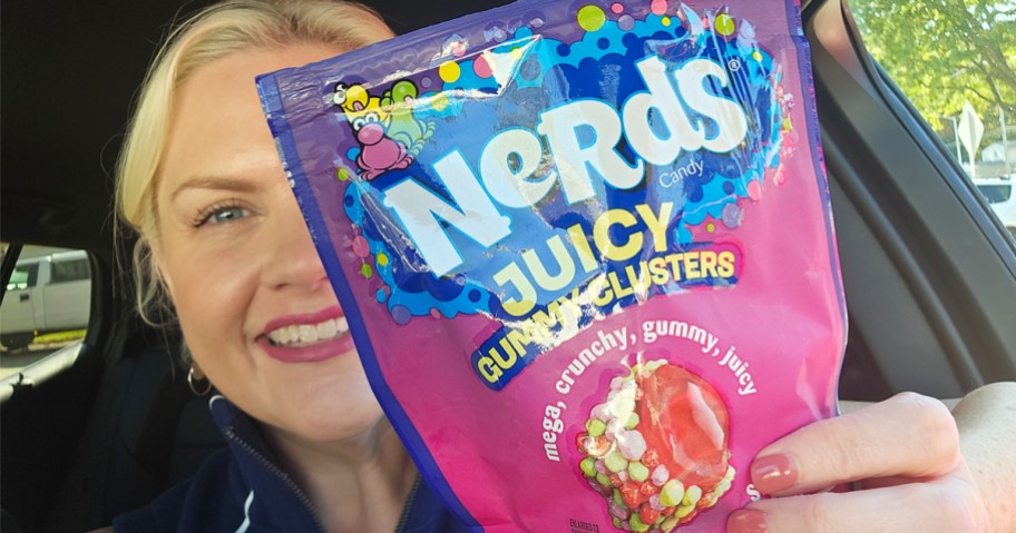woman holding up a bag of NERDS Juicy Gummy Clusters