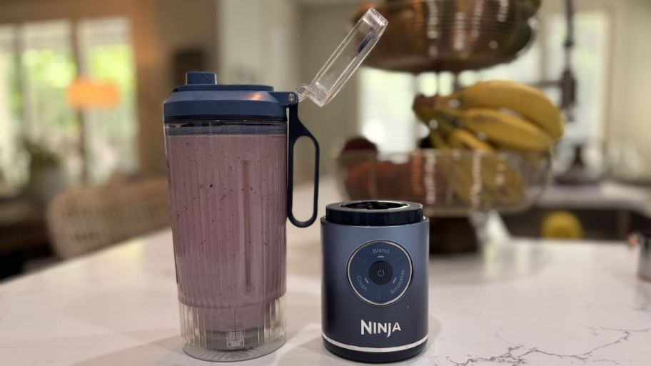 two part Ninja blender MAXX with smoothie inside of it on top of a kitchen table 
