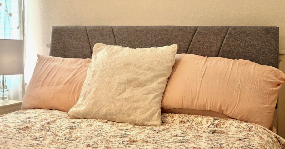 Grey bedframe, flanked with pillows