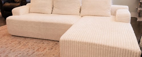White corduroy sectional sofa set up in living room