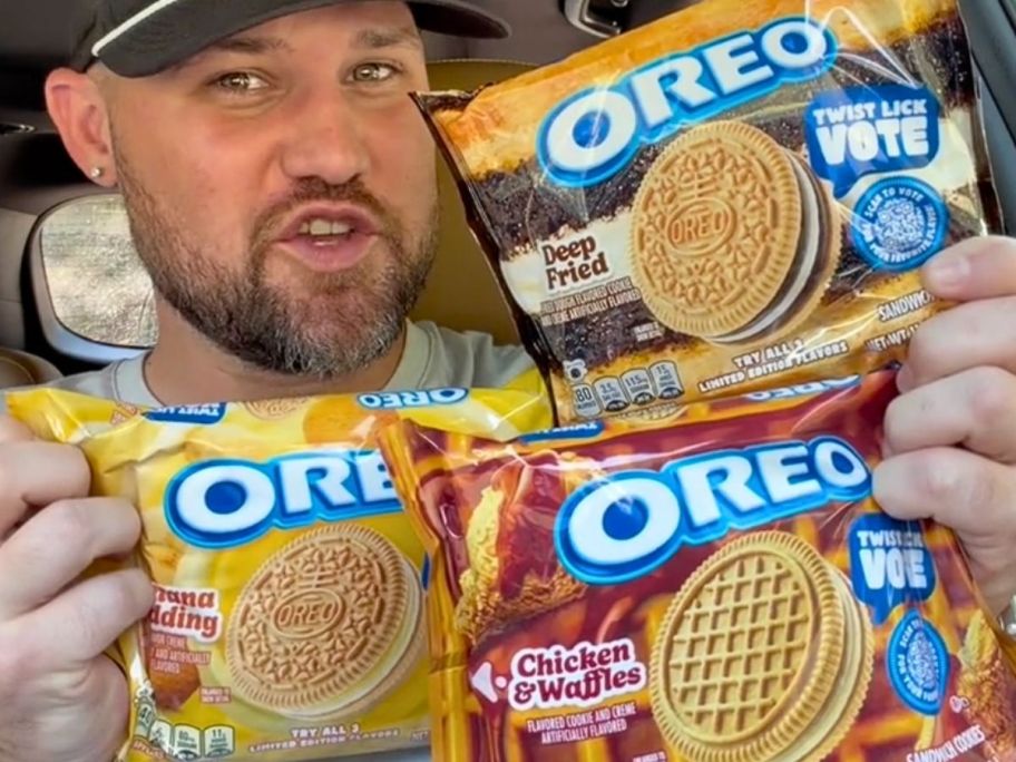 man holding 3 packs of OREO cookies