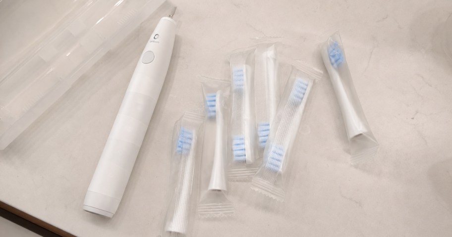 white electric toothbrush with replacement heads on a bathroom counter