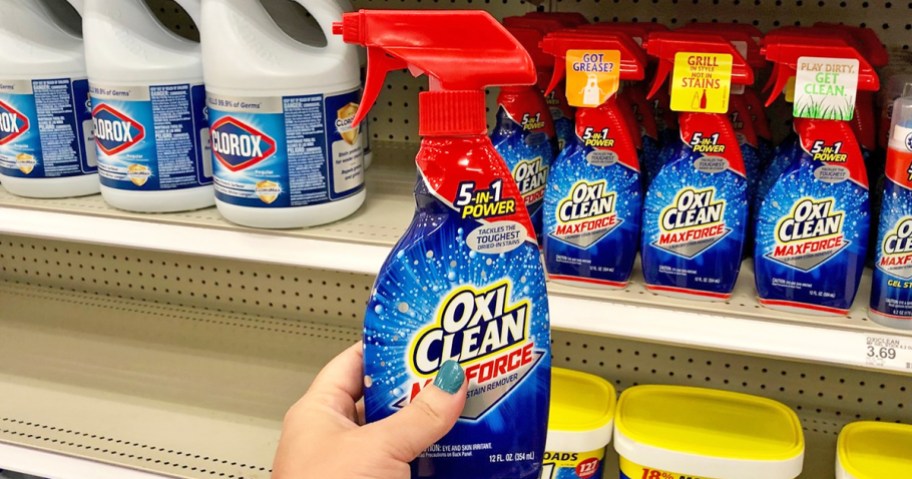 hand holding up a bottle of OxiClean Max Force Laundry Stain Remover in store aisle
