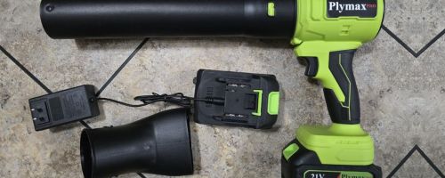 a green cordless leaf blower with accessories on a tile floor