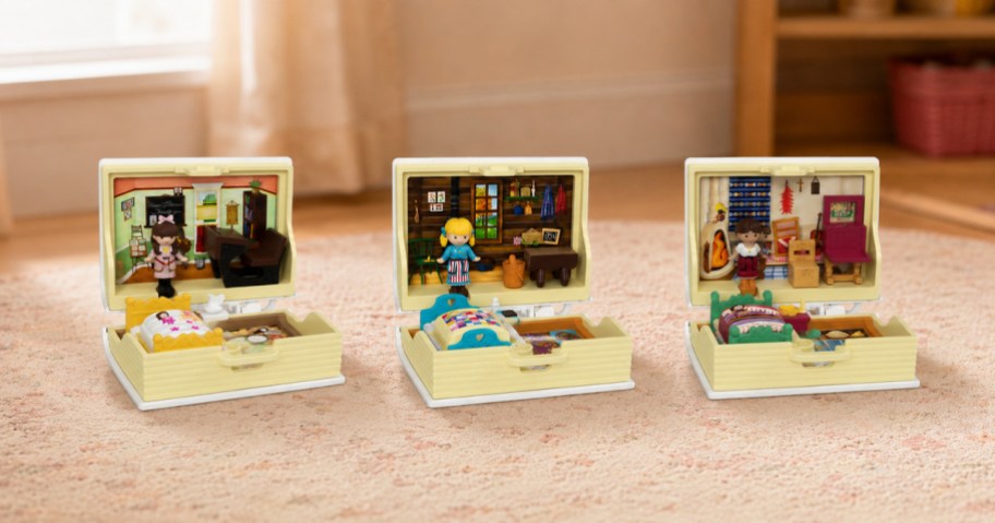 Three Polly Pocket x American Girl compact playsets displayed open in a cozy playroom.