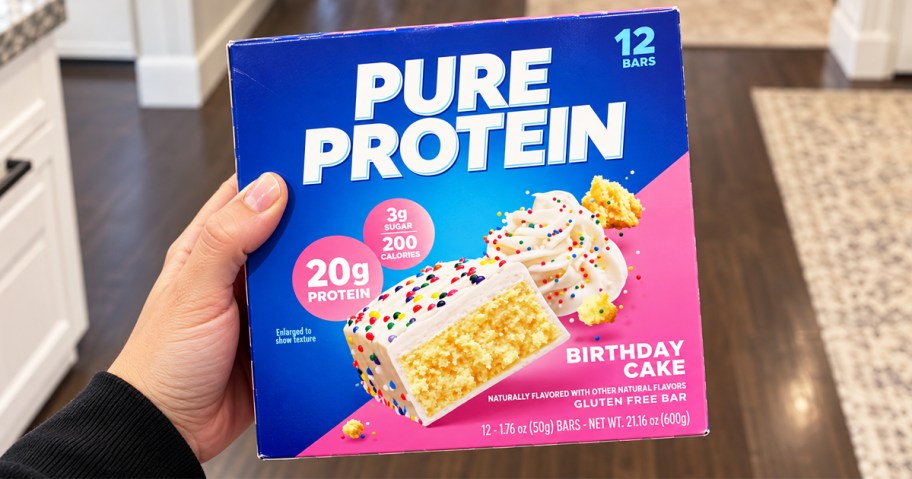 hand holding a box of Pure Protein Bars in kitchen