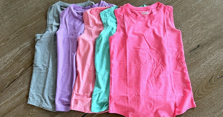 colorful girls tank tops laid on top of one another on the floor