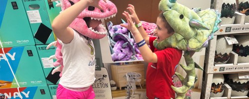 two kids wearing plush dinosaur costumes