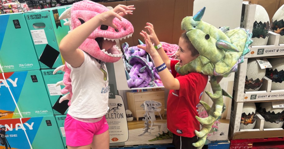 two kids wearing plush dinosaur costumes
