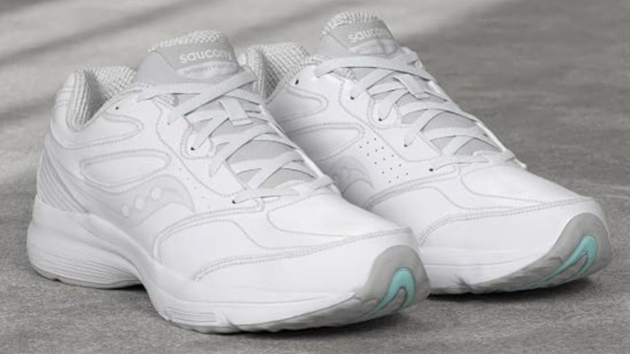 Pair of white Saucony shoes on the floor