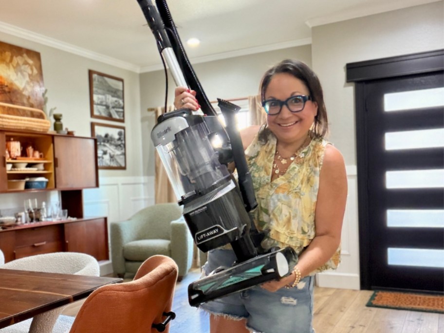 woman holding up a Shark vacuum cleaner