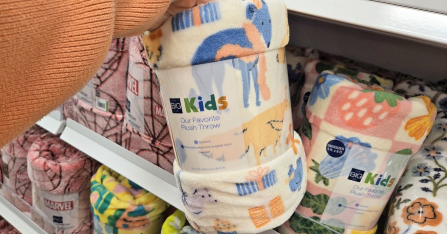 hand holding up a dog print throw blanket in store