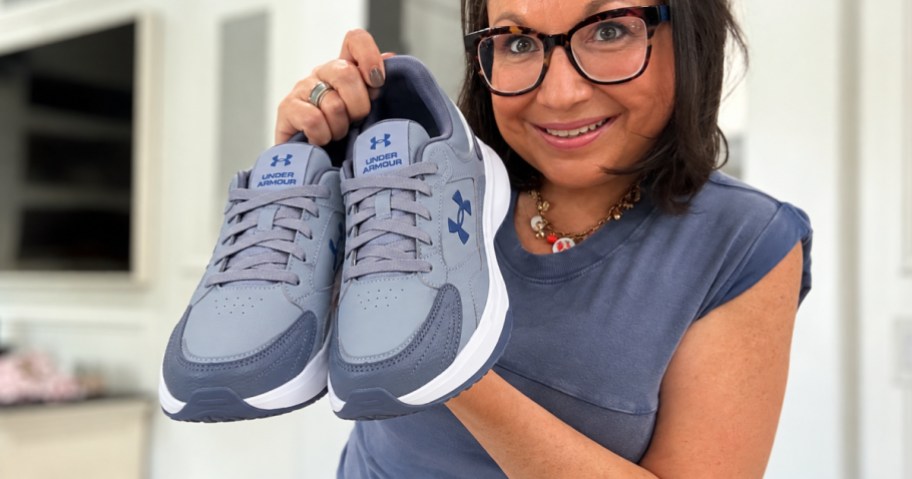 Woman holding Under Armour shoes