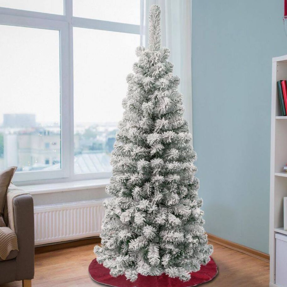 White flocked Christmas tree displayed by the window
