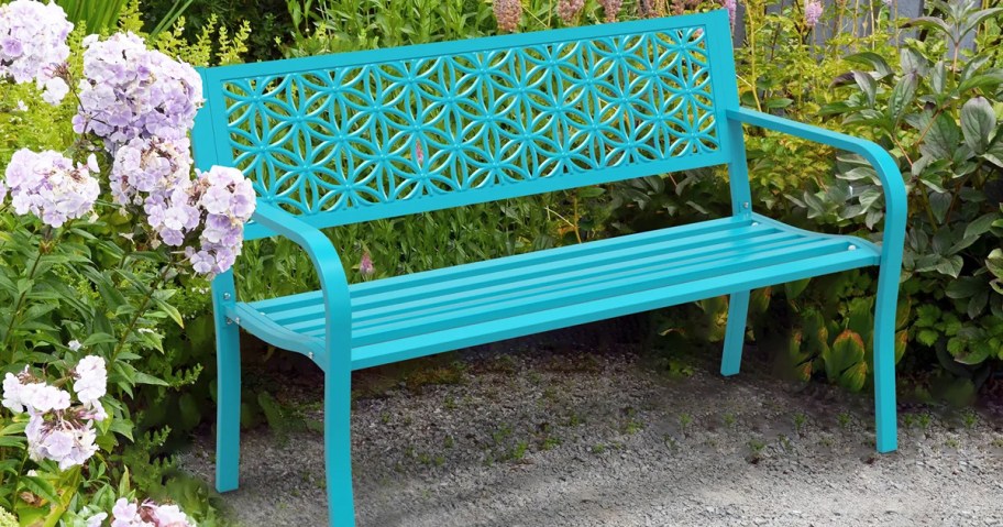 teal metal outdoor bench in a garden