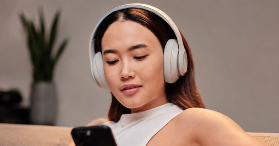 Woman wearing matte white Beats Studio Pro wireless headphones