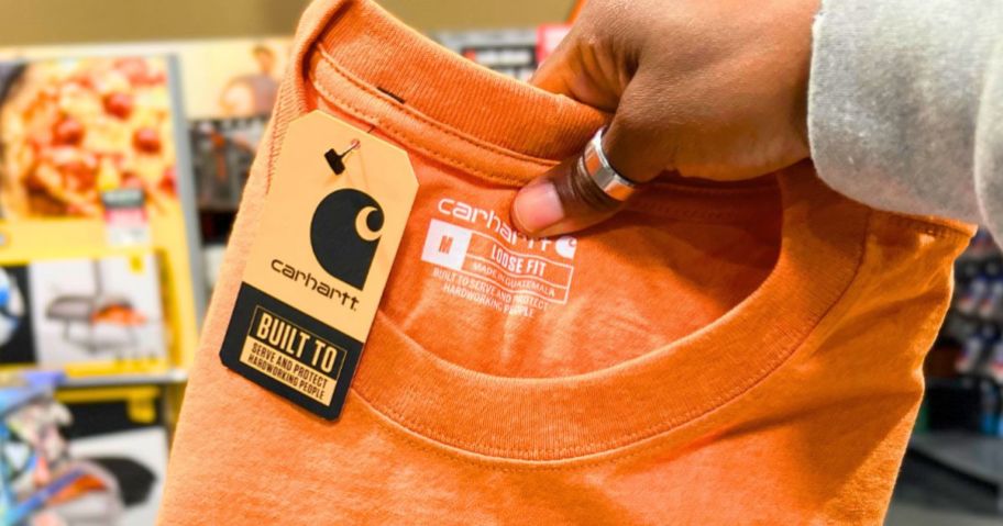 Hand holding a Carhartt T-Shirt