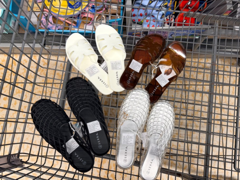 Four pairs of Serra jelly sandals in various colors including white, brown, black, and silver sitting inside a shopping cart.