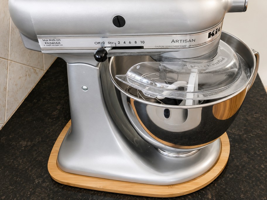 silver stand mixer with wood slider underneath on counter