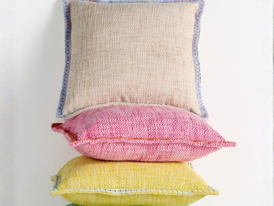 3 outdoor pillows in different colors stacked