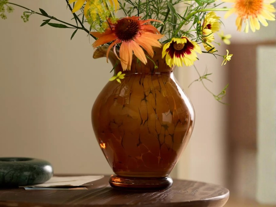 a brown marbled glass vase with flowers